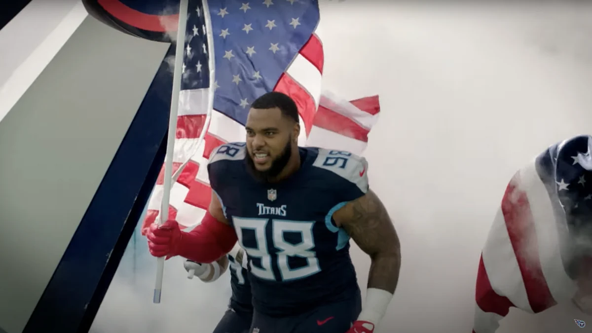 Jeffery Simmons, en tenue des Titans, entre sur le terrain avec un drapeau des États-Unis