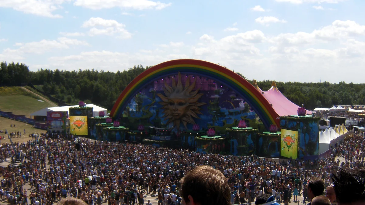 Rainbow-shaped stage facing a large crowd at an outdoor festival
