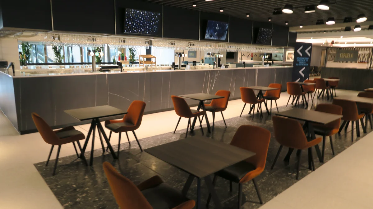 Zona interior con bar, mesas y sillas en el Tottenham Hotspur Stadium