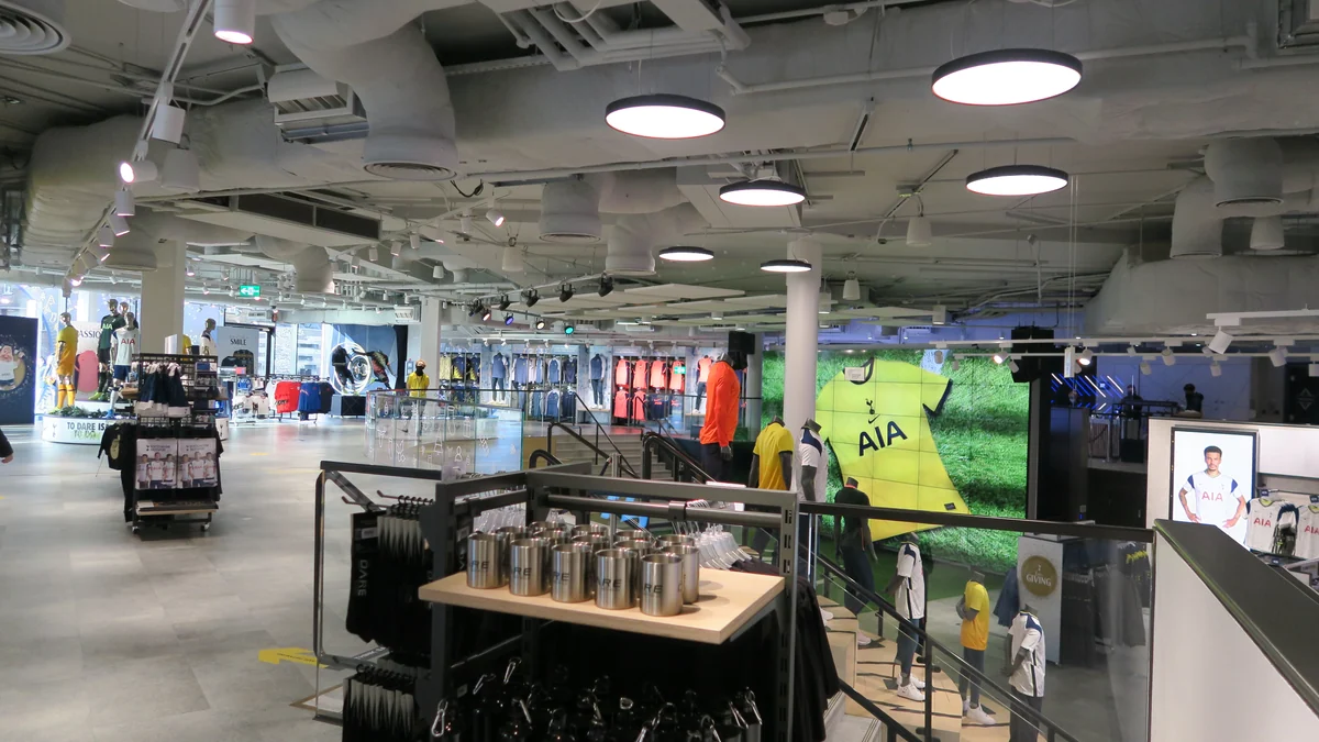 Interior de la tienda del Tottenham con ropa, maniquíes y productos del club