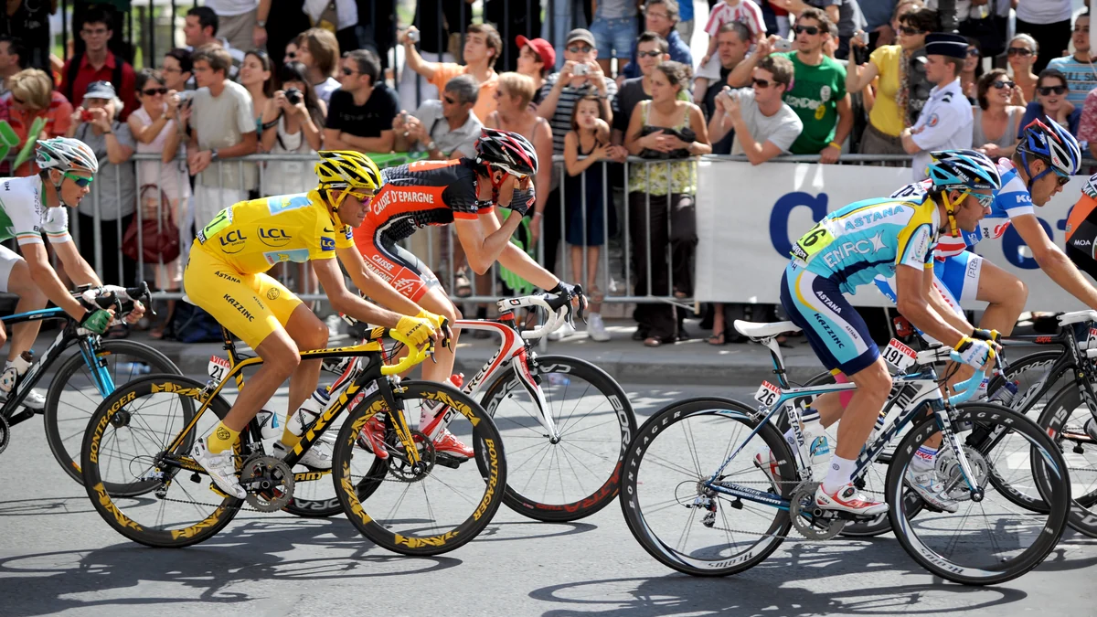 Tour de France riders pass spectators, with Alberto Contador wearing yellow