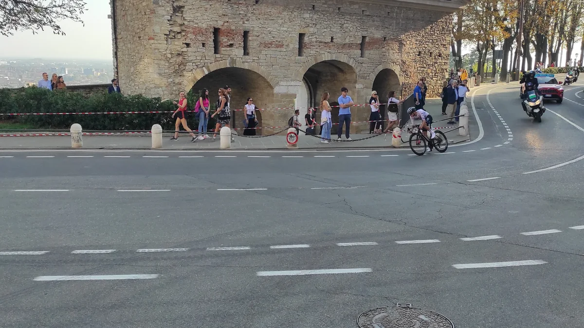 Un cycliste négocie un virage près de la Porta San Giacomo devant des spectateurs