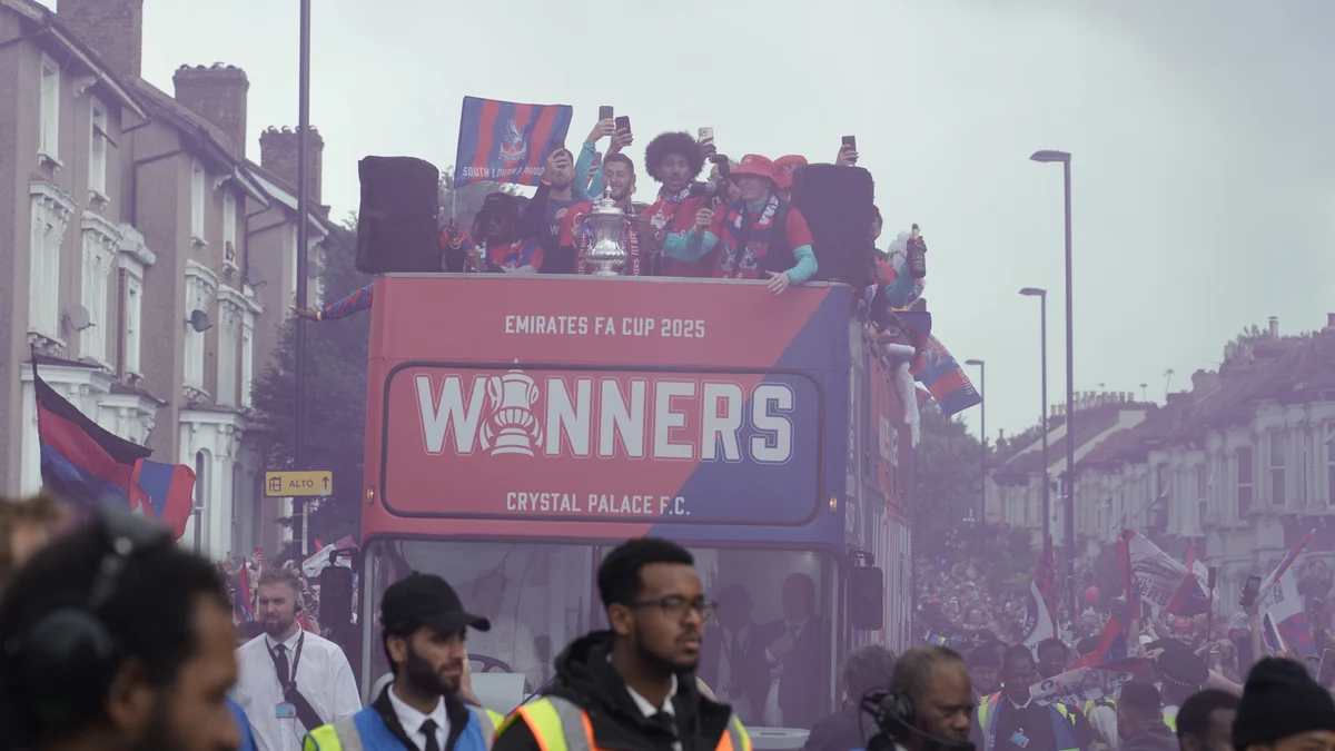 Autobús descubierto del Crystal Palace con jugadores y un trofeo entre una multitud