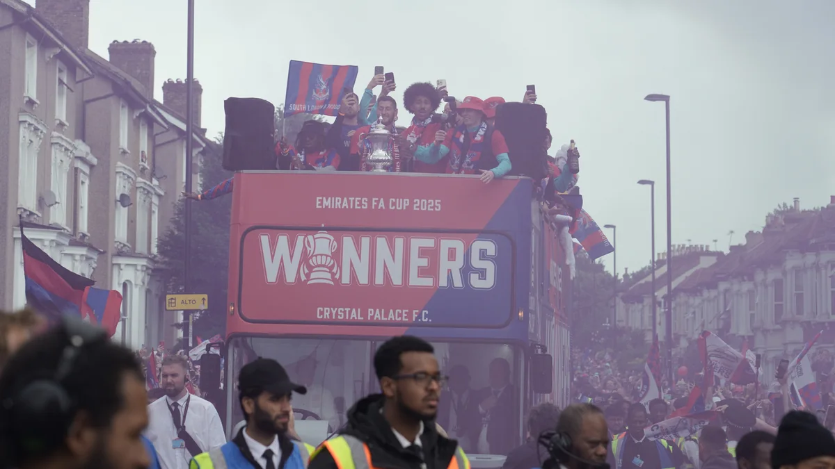 Ônibus aberto do Crystal Palace com jogadores e troféu em meio a uma multidão