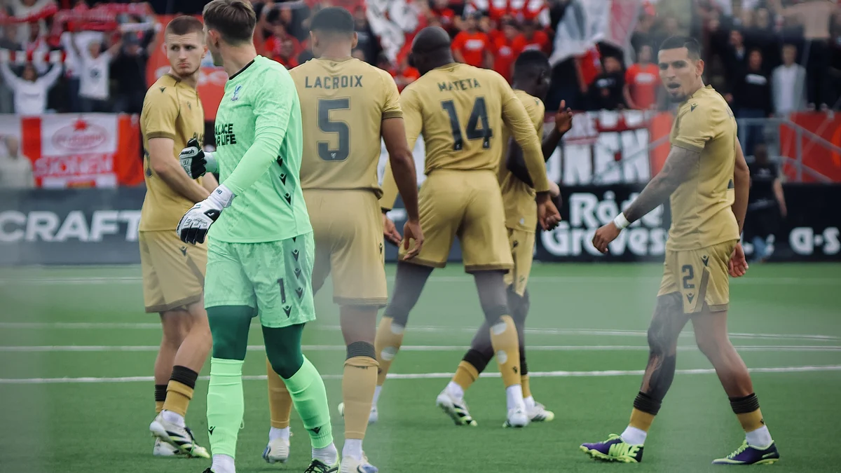 Portero de verde y jugadores del Crystal Palace con uniformes dorados en el campo