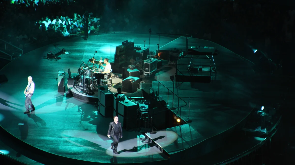U2 se produit sur une scène circulaire éclairée en vert, vue d’en haut