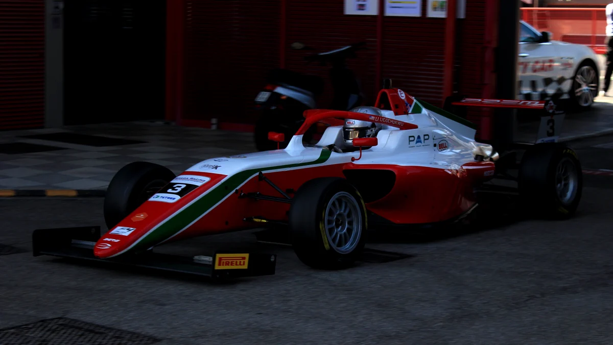 Monoposto branco, vermelho e verde número 3 sai de uma garagem