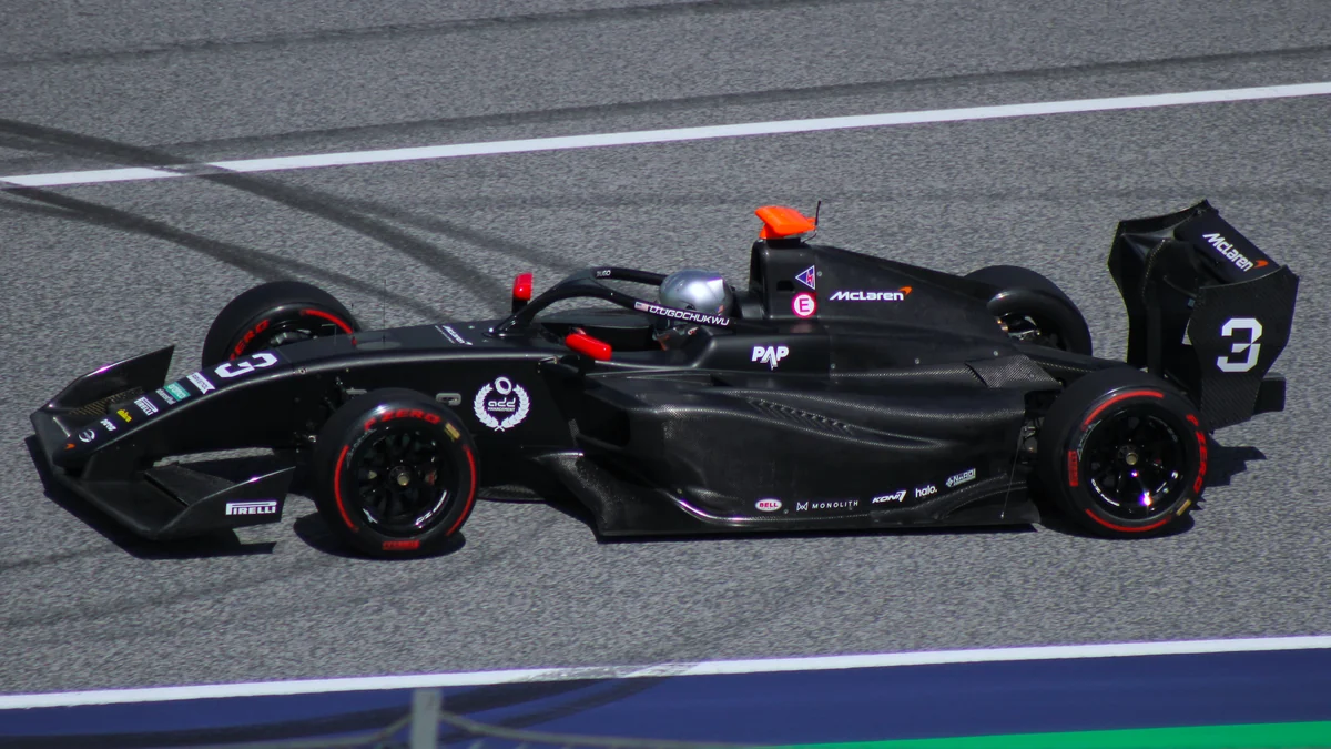 Carro preto de Fórmula 3 número 3 visto de lado sobre a pista