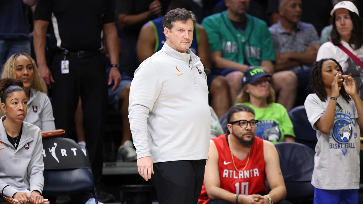 Integrante del cuerpo técnico del Atlanta Dream, con sudadera blanca, observa desde la banda