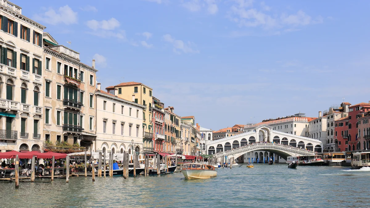 Venice Grand Canal with Rialto Bridge, boats and buildings along the banks