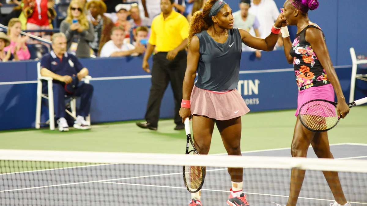 Serena Williams touche le visage de Venus Williams pendant un match de double