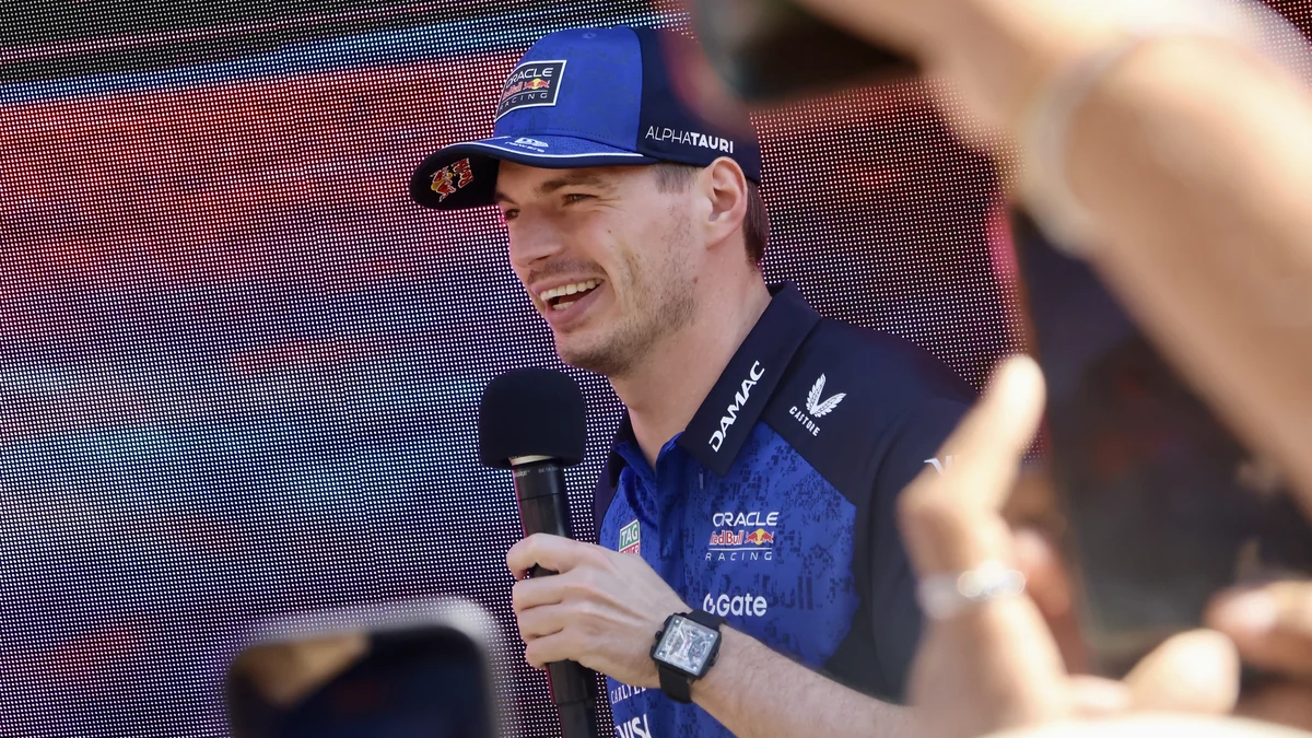 Max Verstappen sonríe mientras sostiene un micrófono en un evento de Red Bull