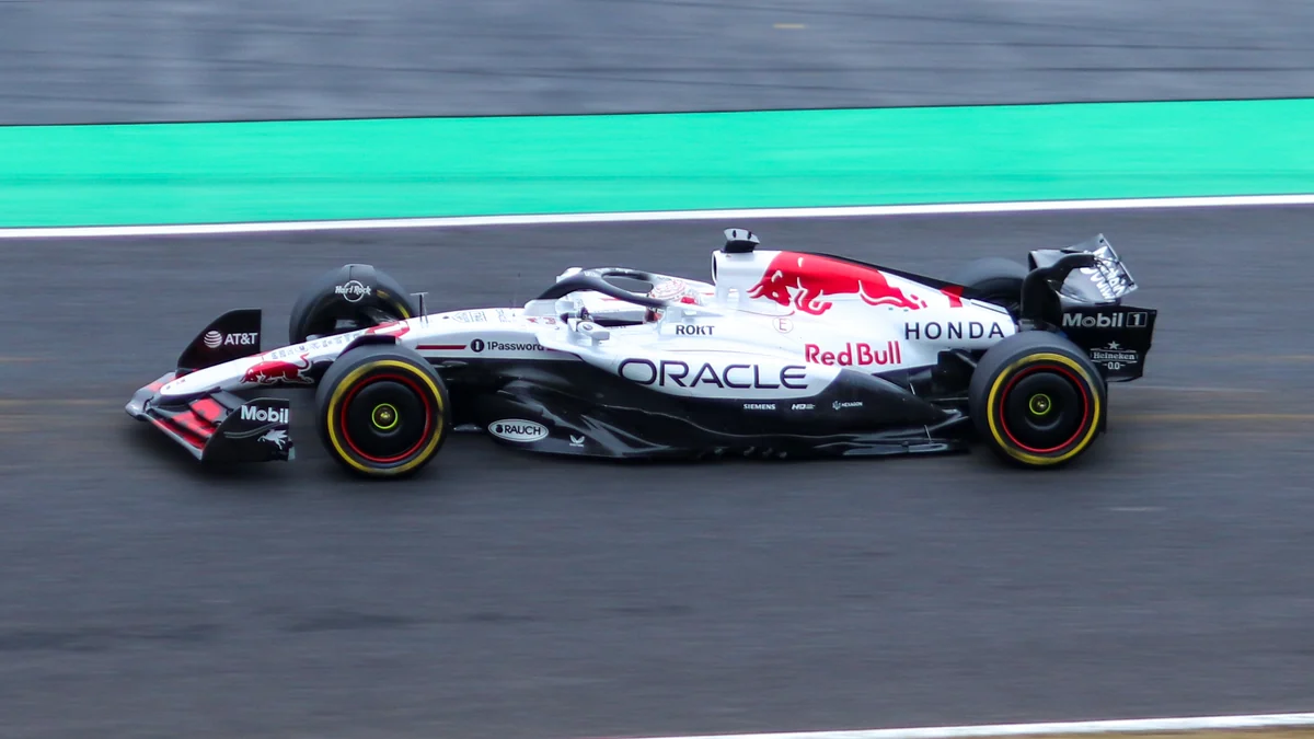 Monoplaza blanco, negro y rojo de Red Bull visto de lado a gran velocidad en pista