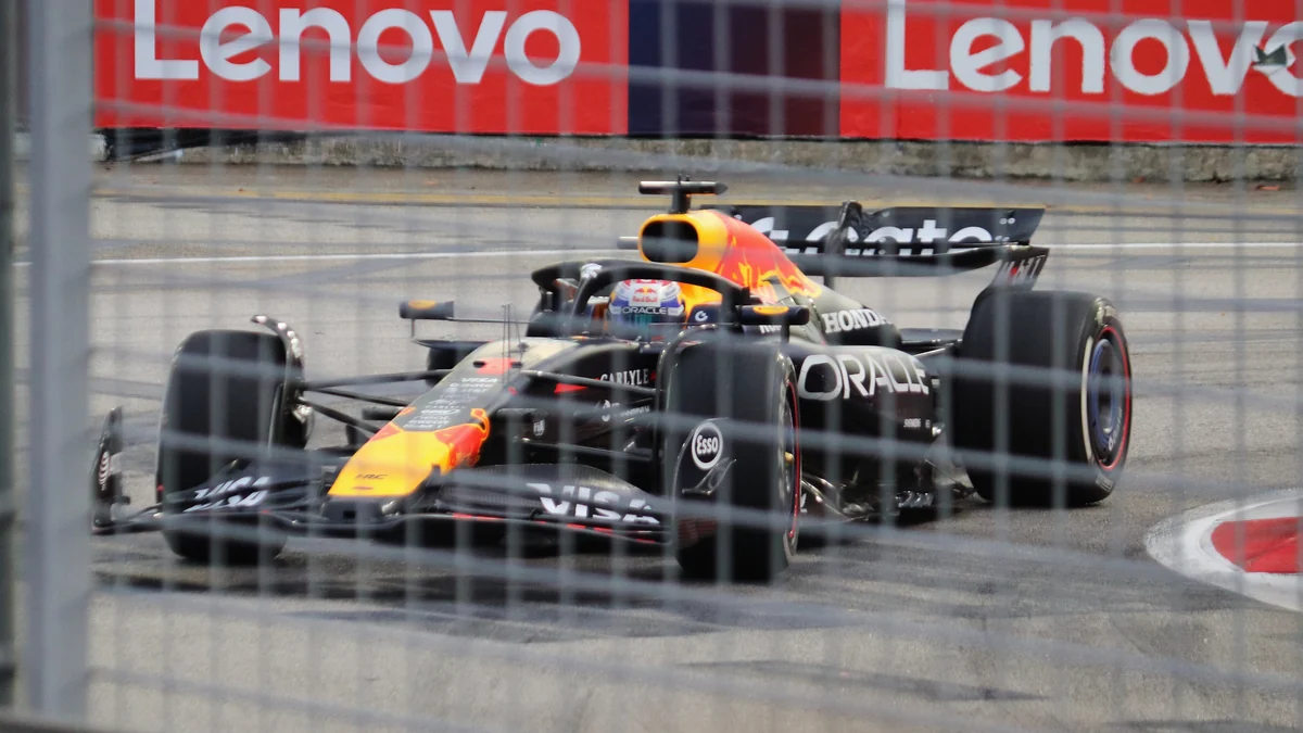 Monoplaza de Red Bull toma una curva urbana visto a través de la valla de protección