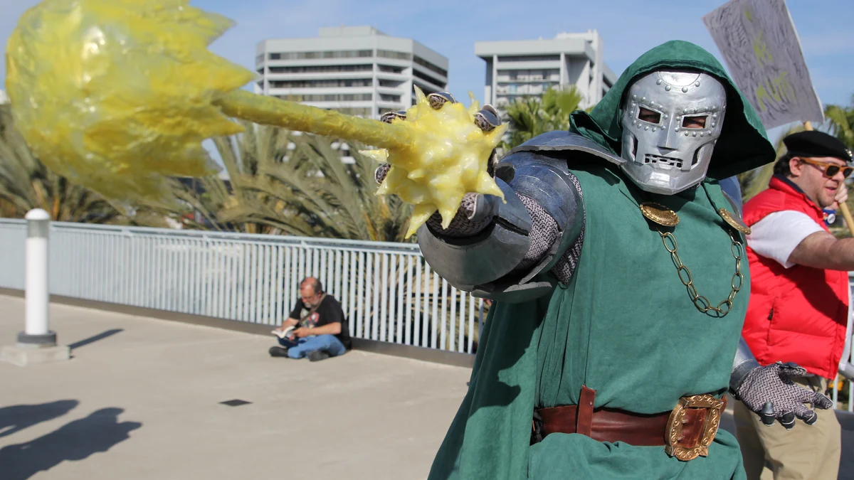 Cosplayer de Doctor Doom pointe un accessoire jaune vers l’appareil photo en extérieur