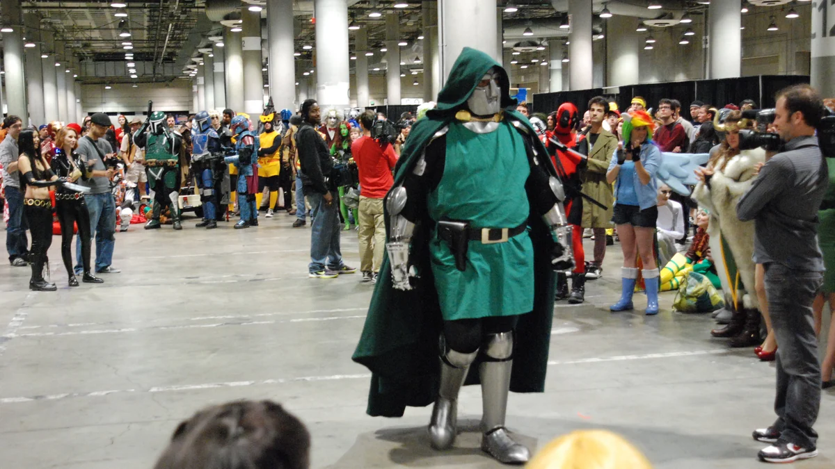Cosplayer de Doctor Doom marche dans un hall entouré de participants costumés