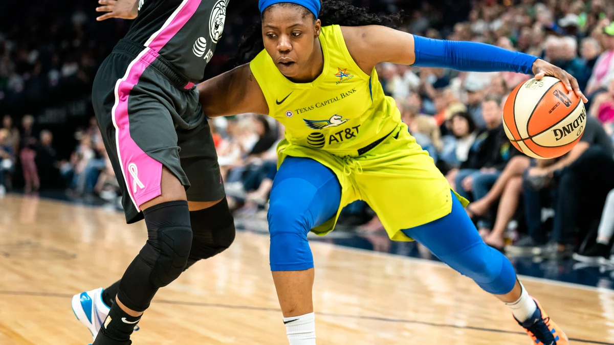 Arike Ogunbowale dribble face à une défenseuse pendant un match