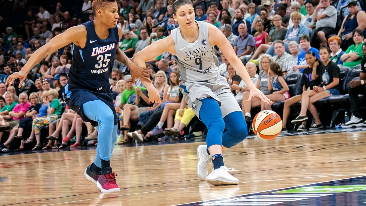 Una jugadora de Minnesota Lynx bota el balón junto a una defensora de Atlanta Dream con el número 35.