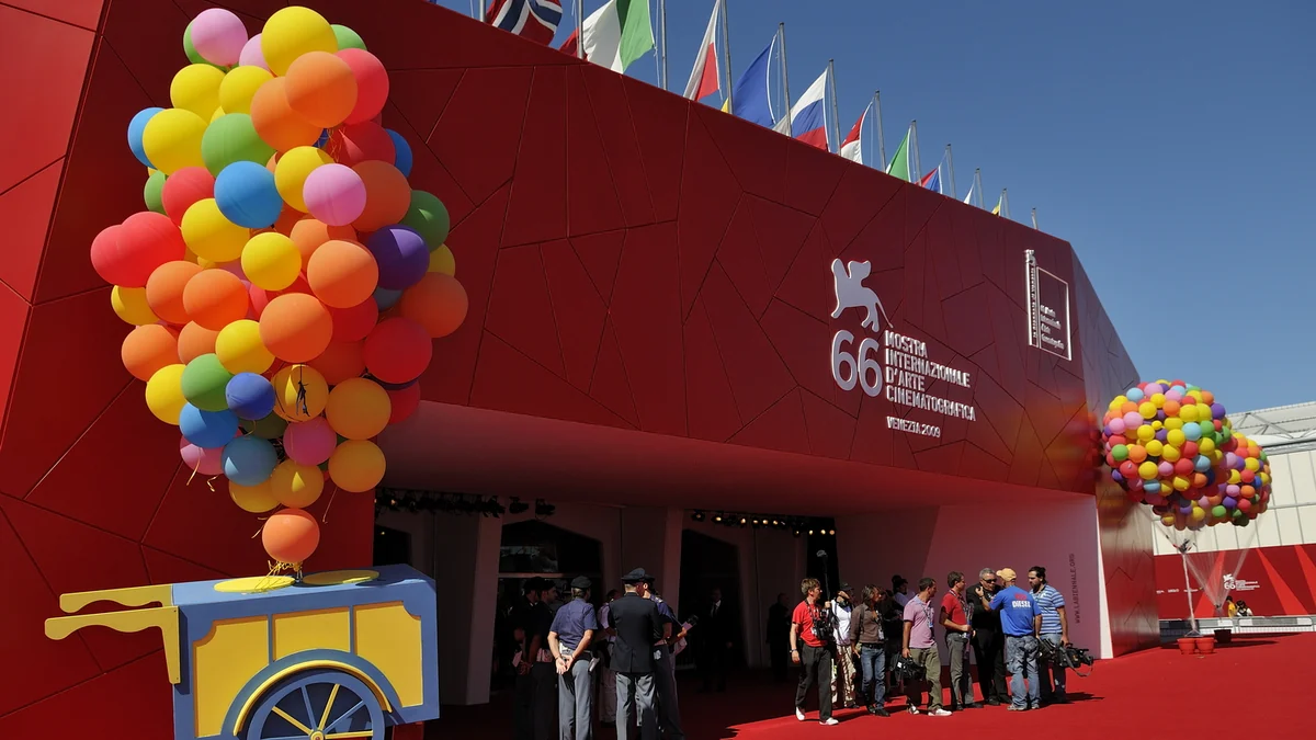 Red entrance to the 66th Venice Film Festival decorated with large clusters of colorful balloons.