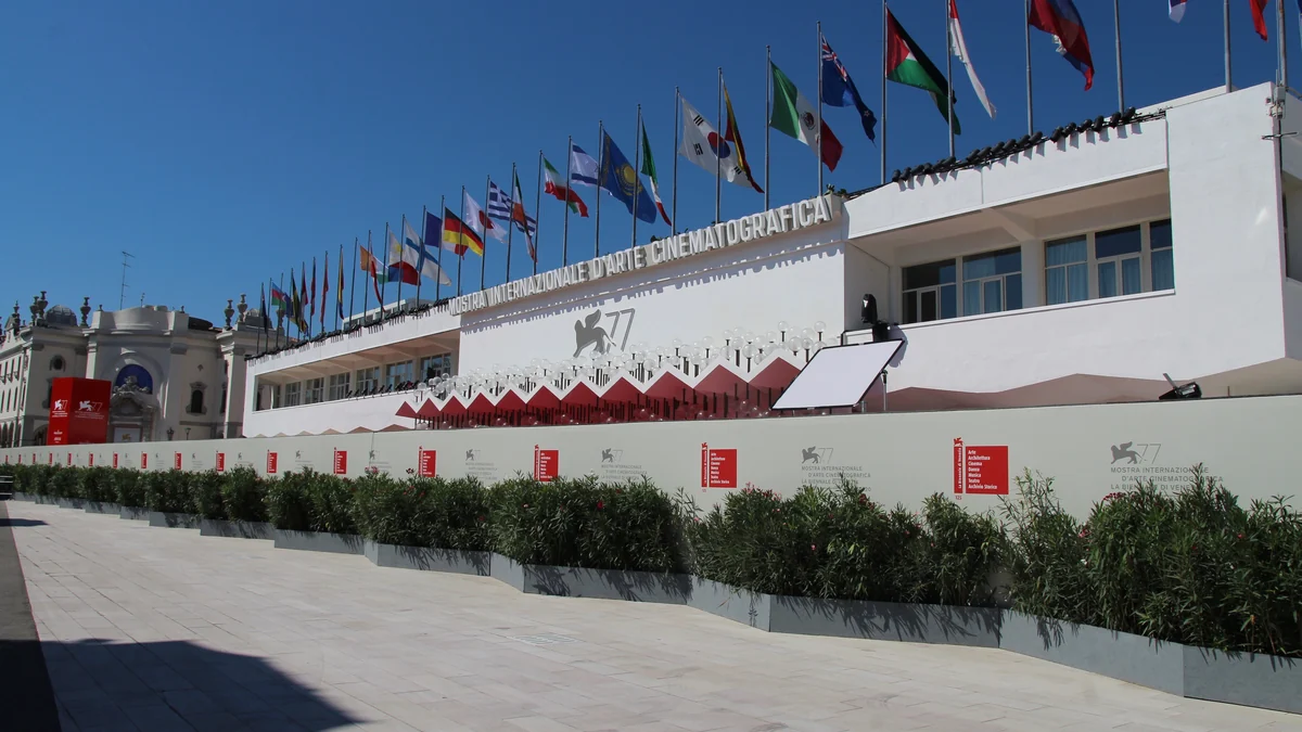 White Venice Film Festival building with international flags lined across the roof.