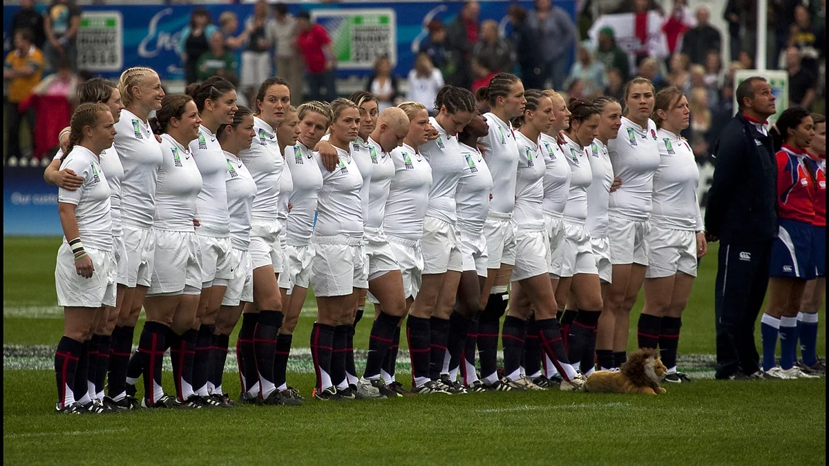 Les joueuses de l’équipe d’Angleterre de rugby sont alignées et se tiennent par les épaules