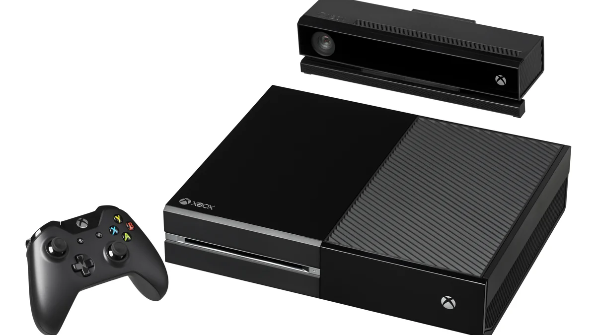 Consola Xbox One negra con mando y sensor Kinect sobre fondo blanco